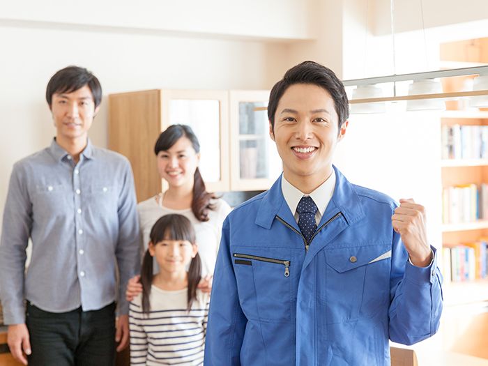 青い作業着を着た男性と家族